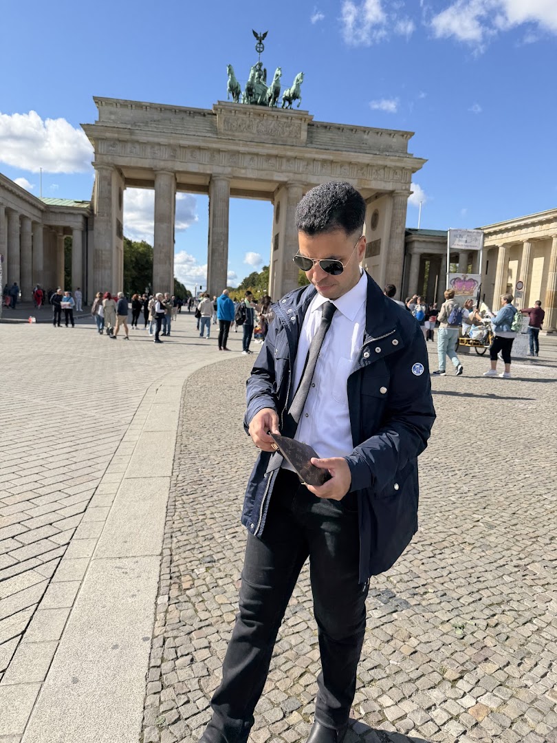 Ahmed in a suit and sunglasses at the Brandenburg Gate